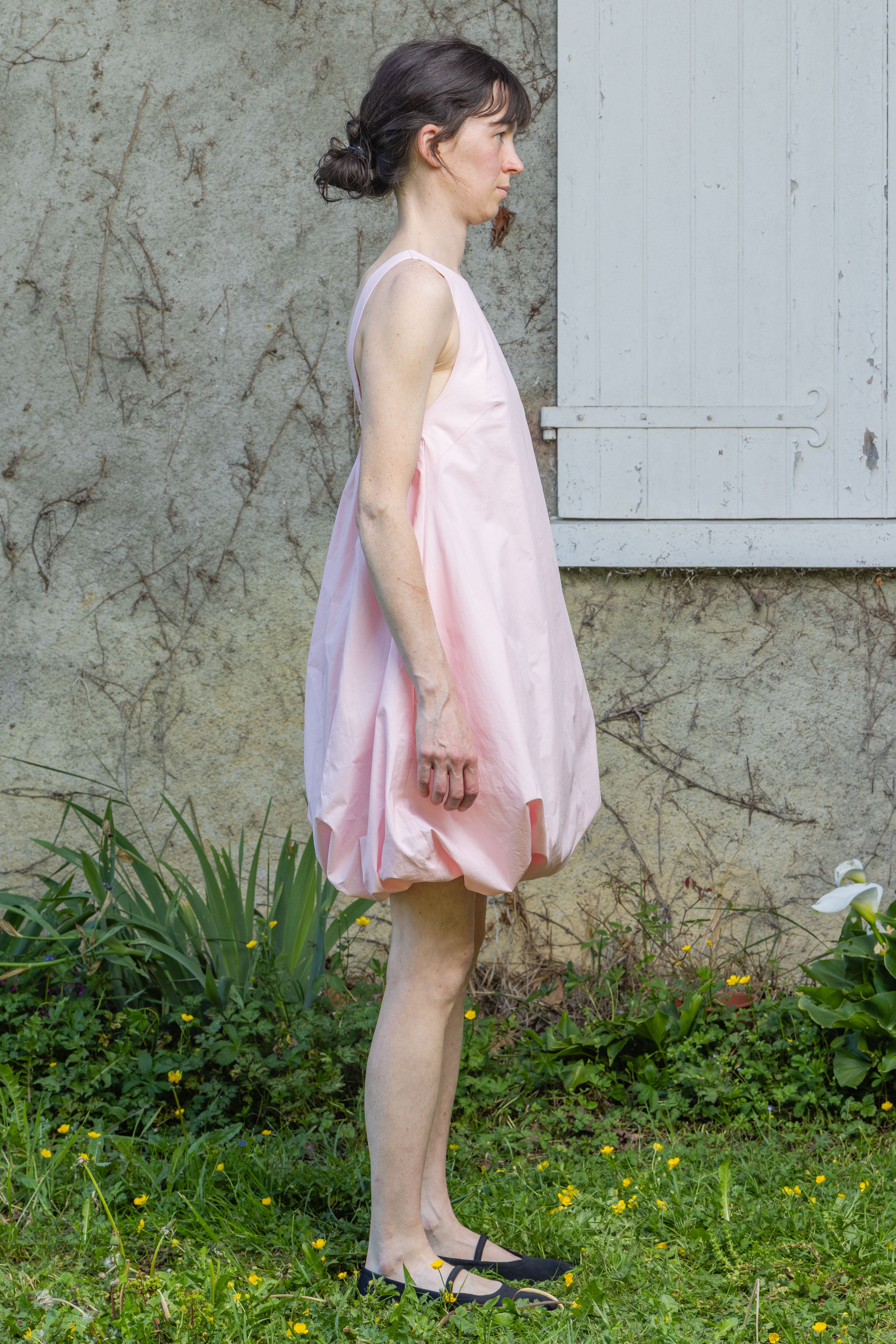 Pink bubble dress with open back, thin straps, and gathered skirt hem