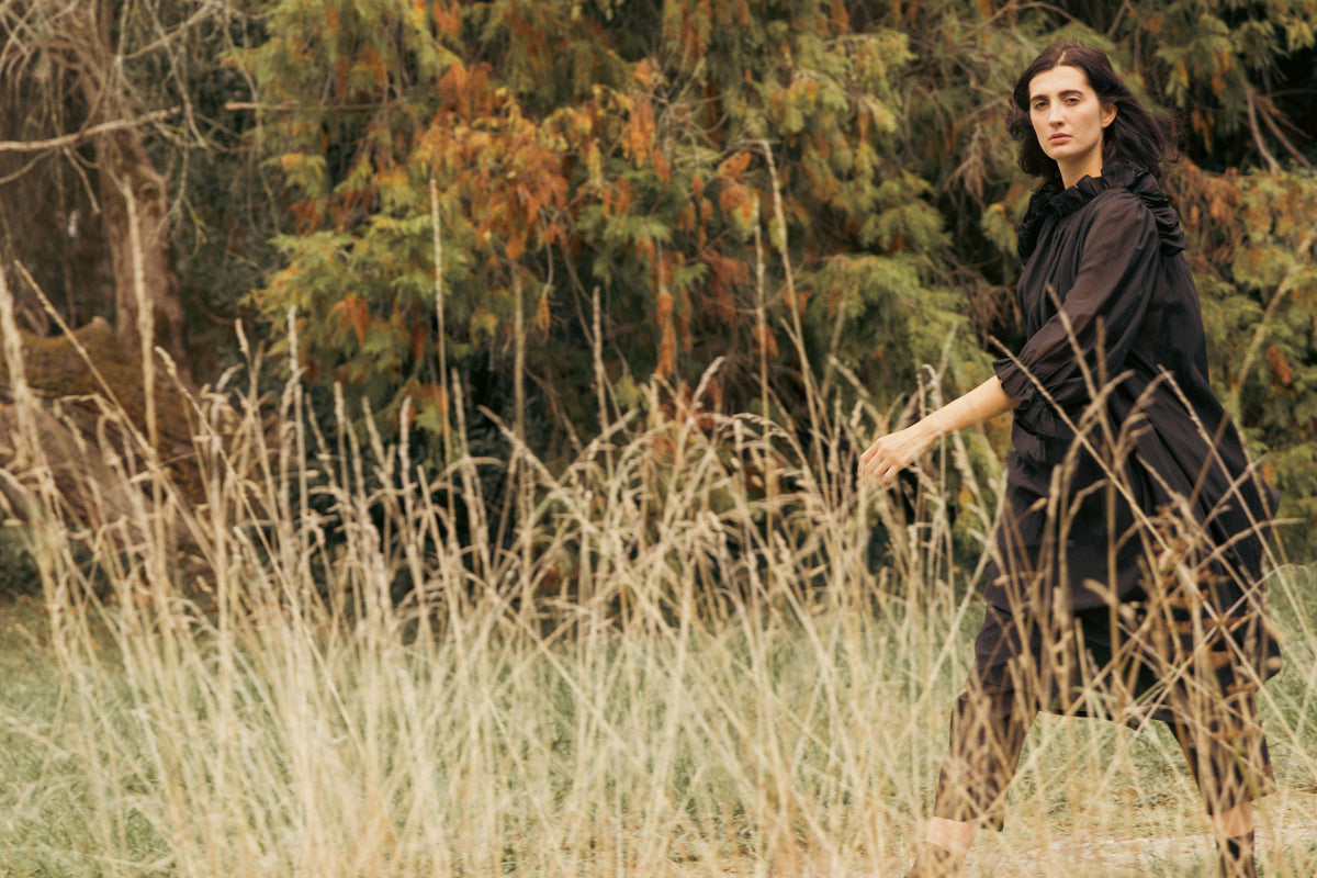 Black flowing maxi dress with ruffled collar and wide billowy sleeves