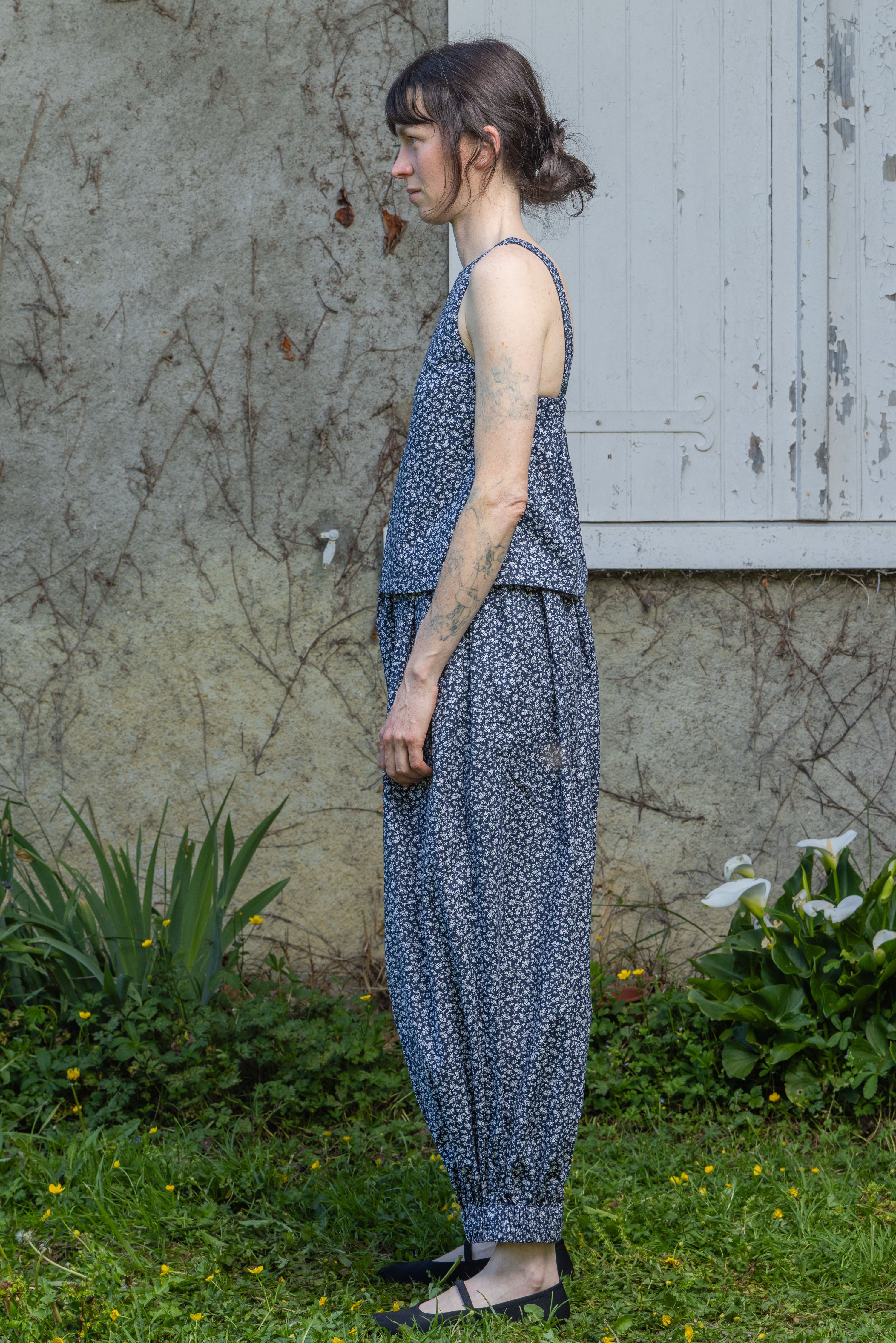 Navy floral sleeveless tank top, side view, round neck and gathered waist hem