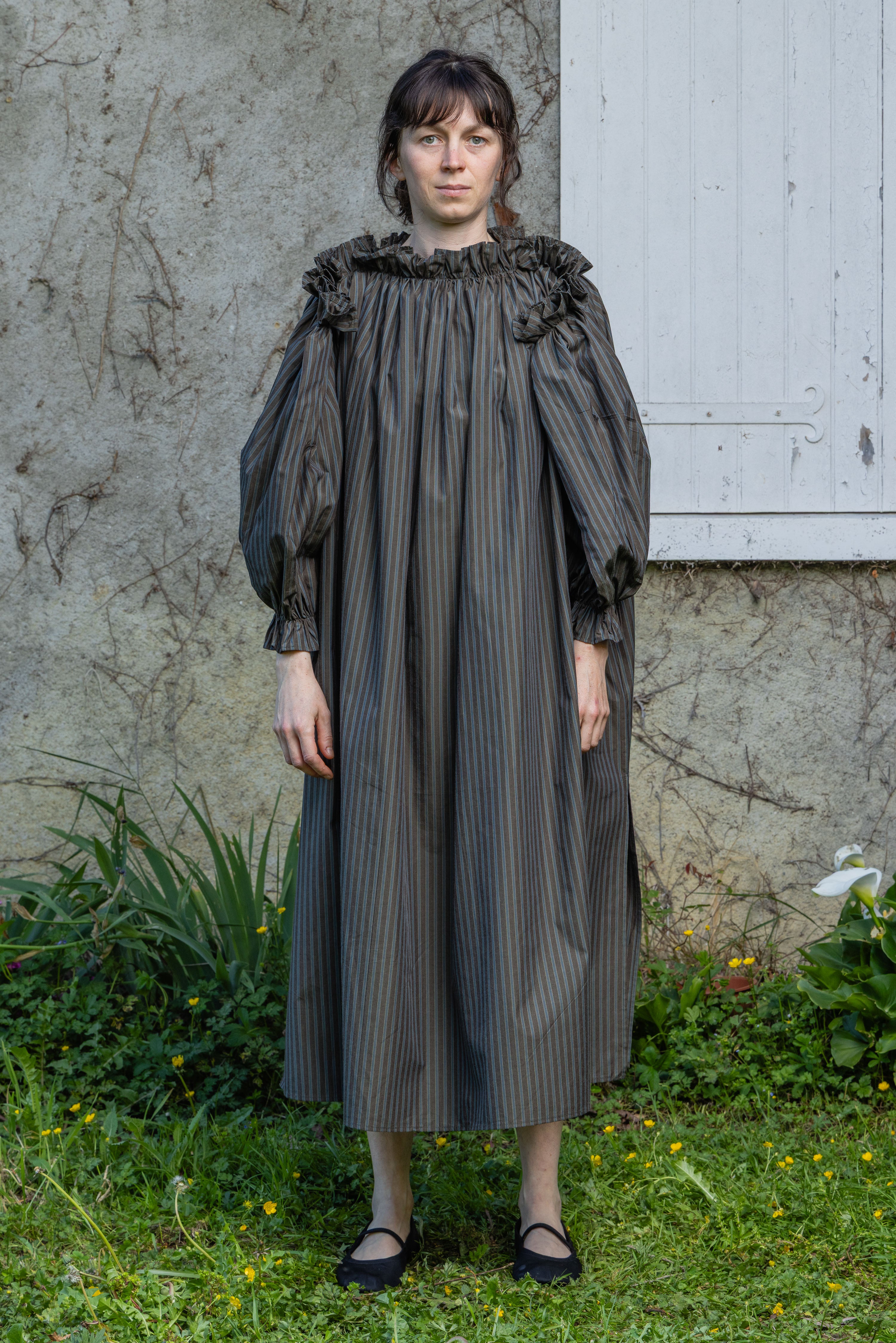 Dark olive striped midi dress with ruffled high collar and gathered sleeves.