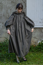Dark olive striped midi dress with ruffled collar and oversized puff sleeves.