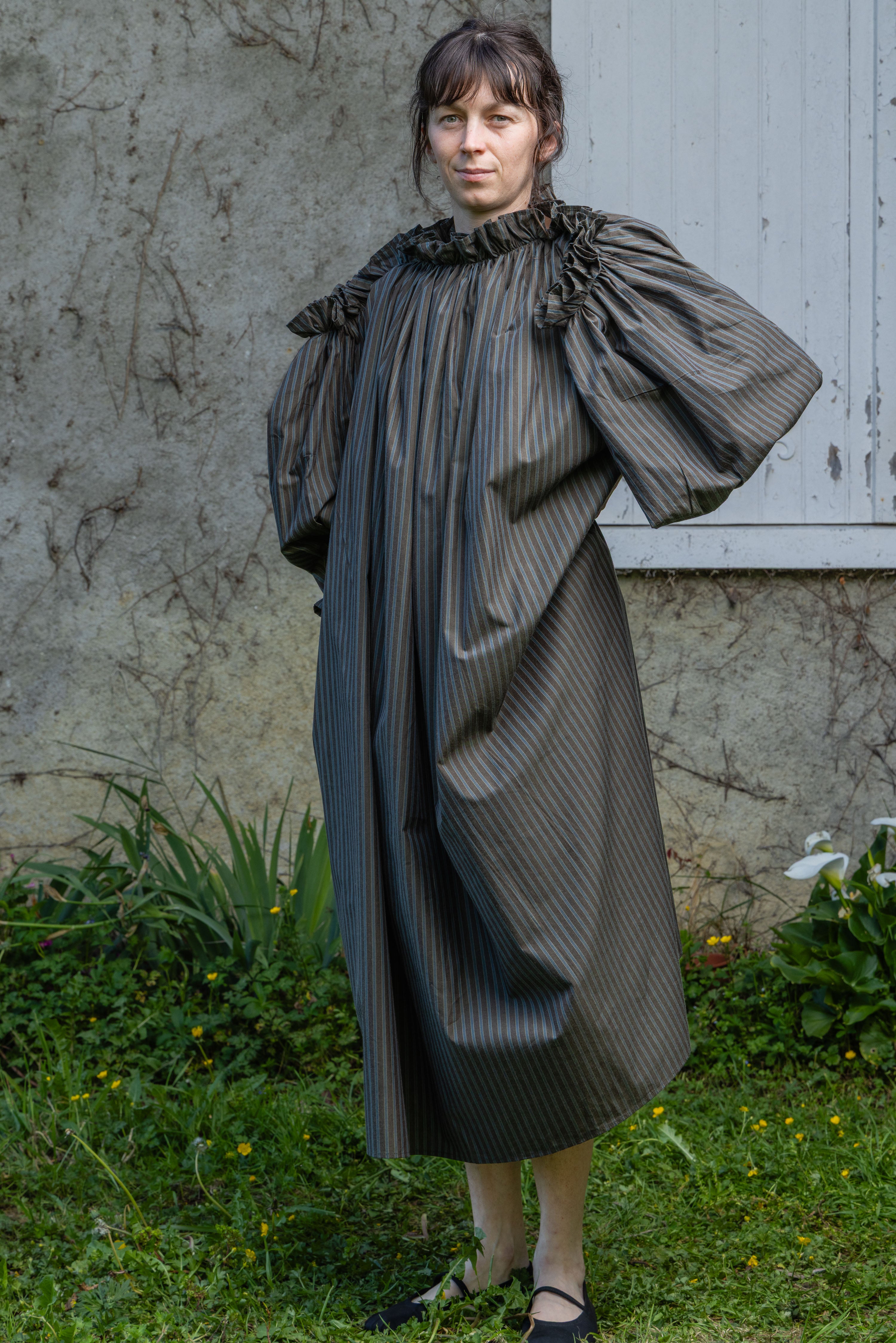 Dark olive striped midi dress with ruffled neckline and voluminous puff sleeves.