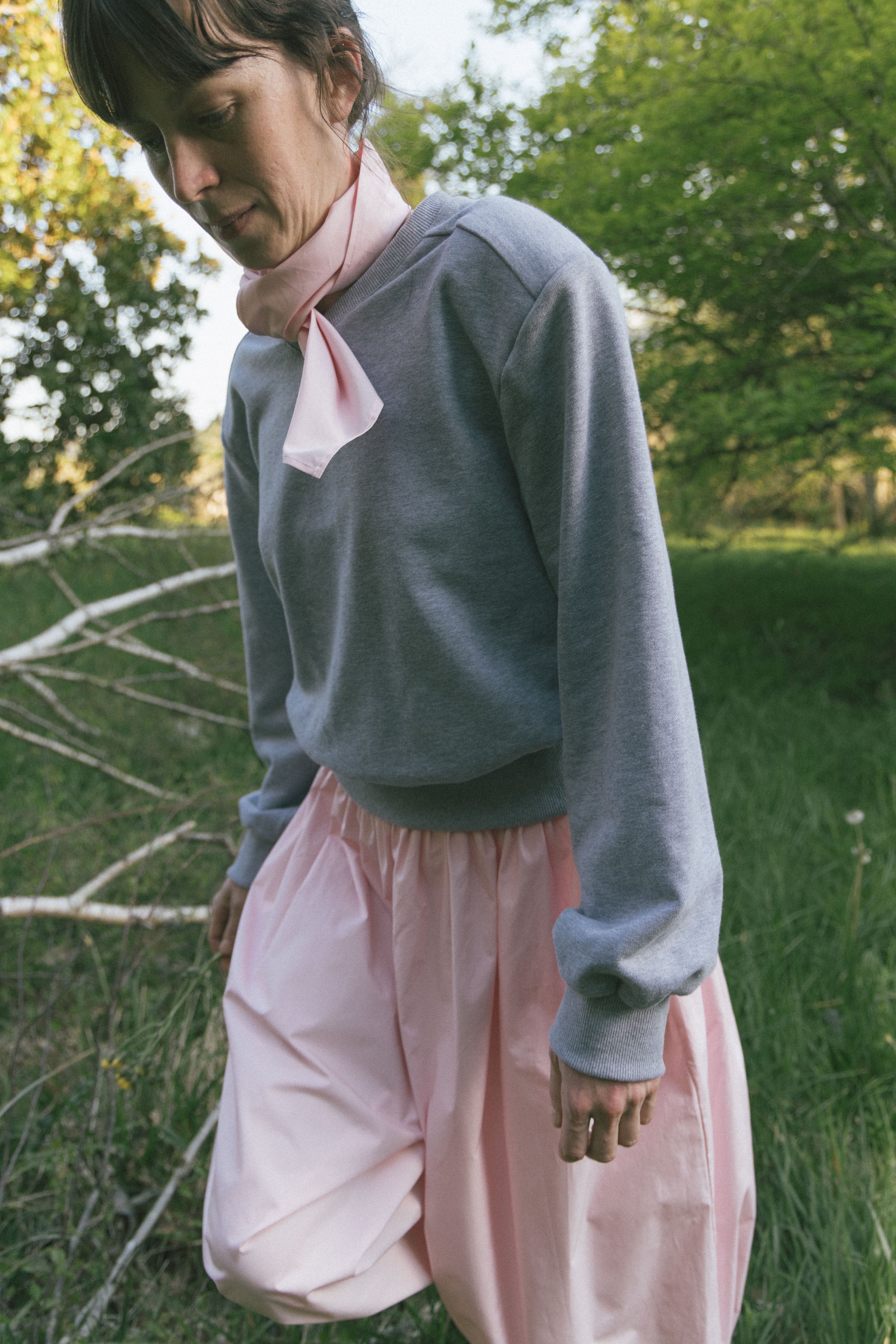 Heather grey V-neck knit top with long sleeves and ribbed cuffs, side view