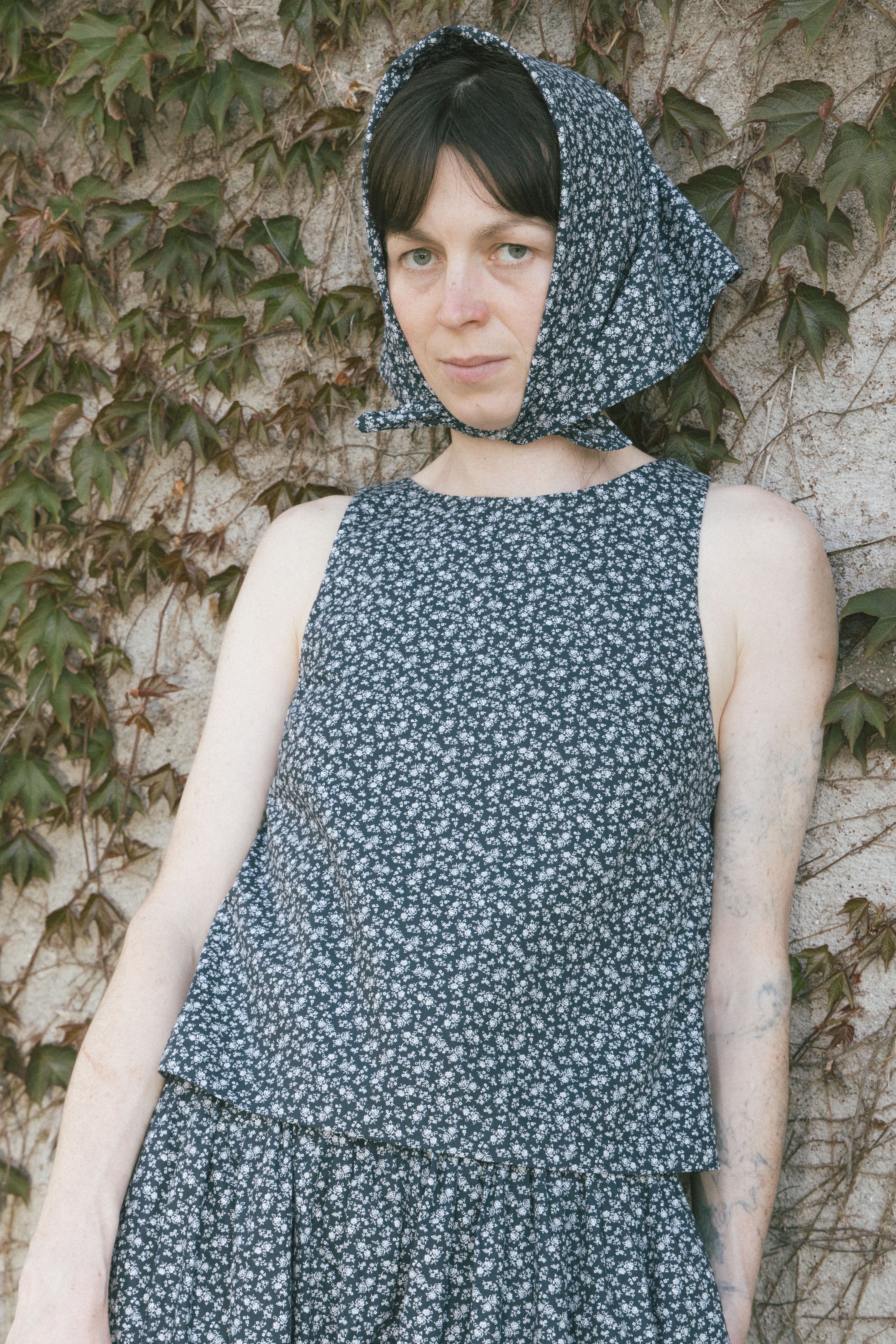 Navy floral sleeveless tank top with draped hood detail at neckline